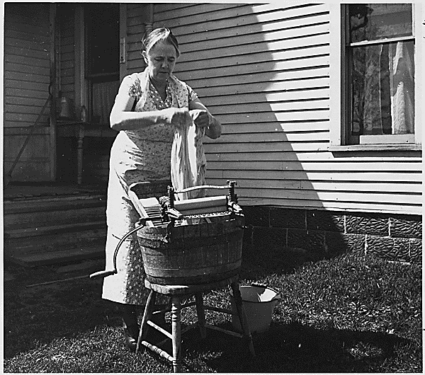 Doing the laundry in the 1960s. A lady is using a washboard to