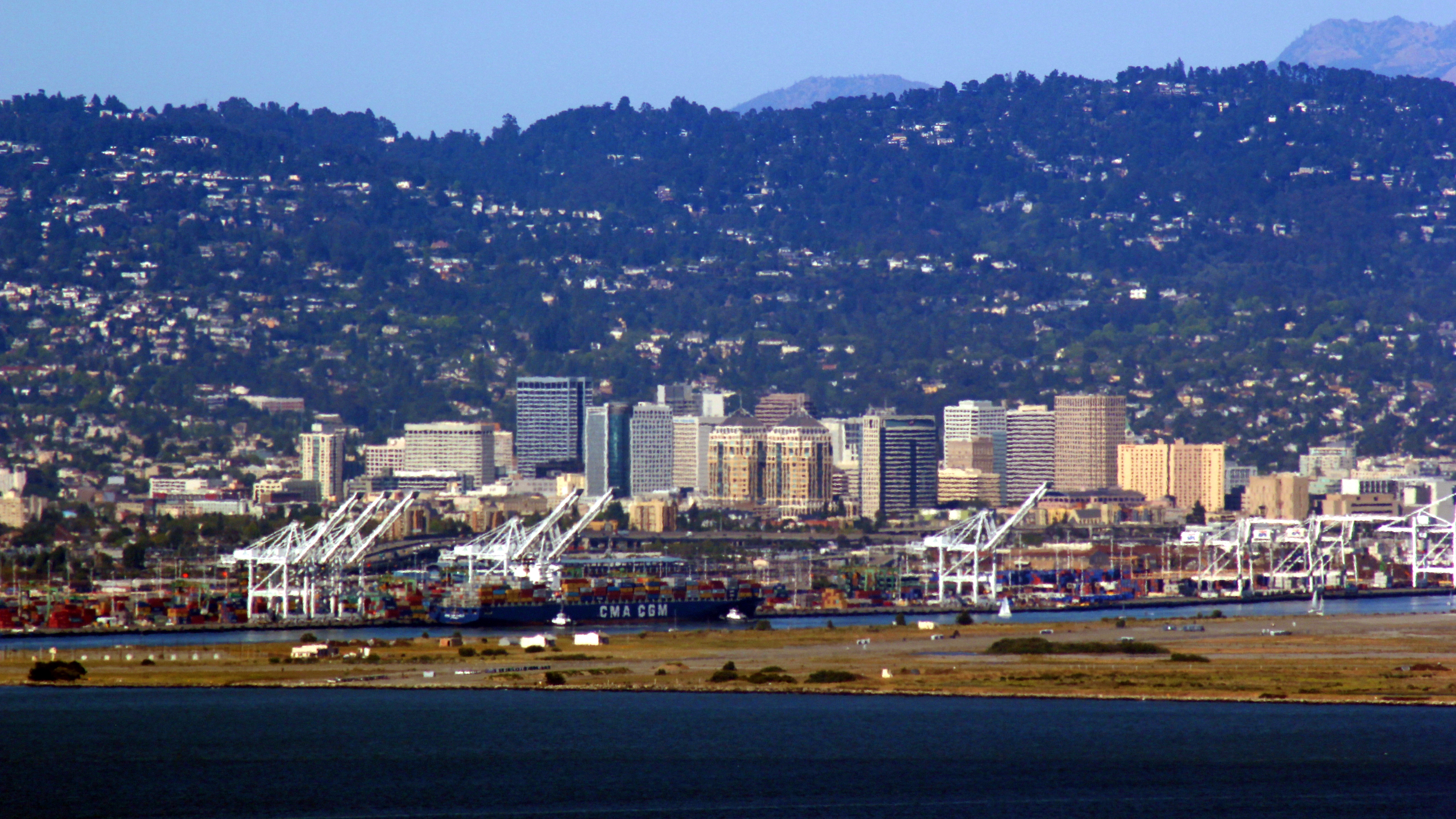 (foreground to background) Port of Oakland, Downtown Oakland skyline, and Oakland hills