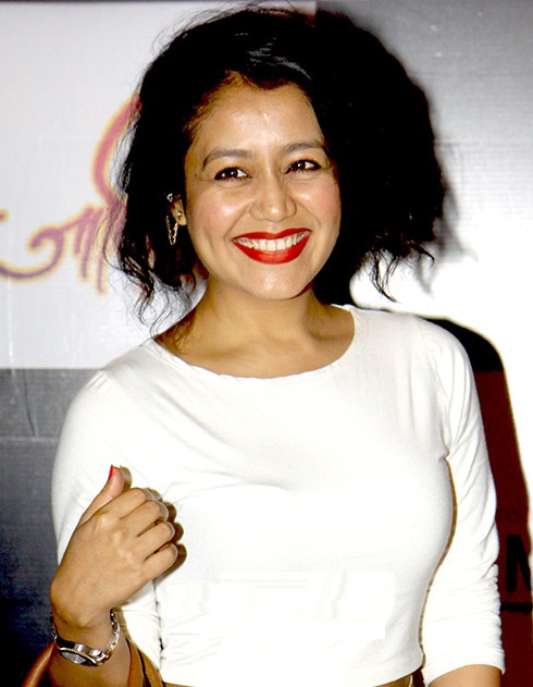 Neha Kakkar smiling looking at camera wearing a white top