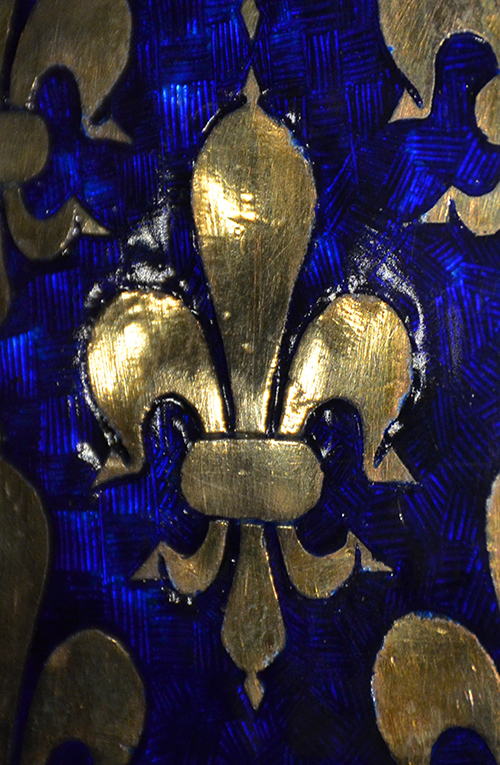 A stylised fleur-de-lys in gold agains a blue background.