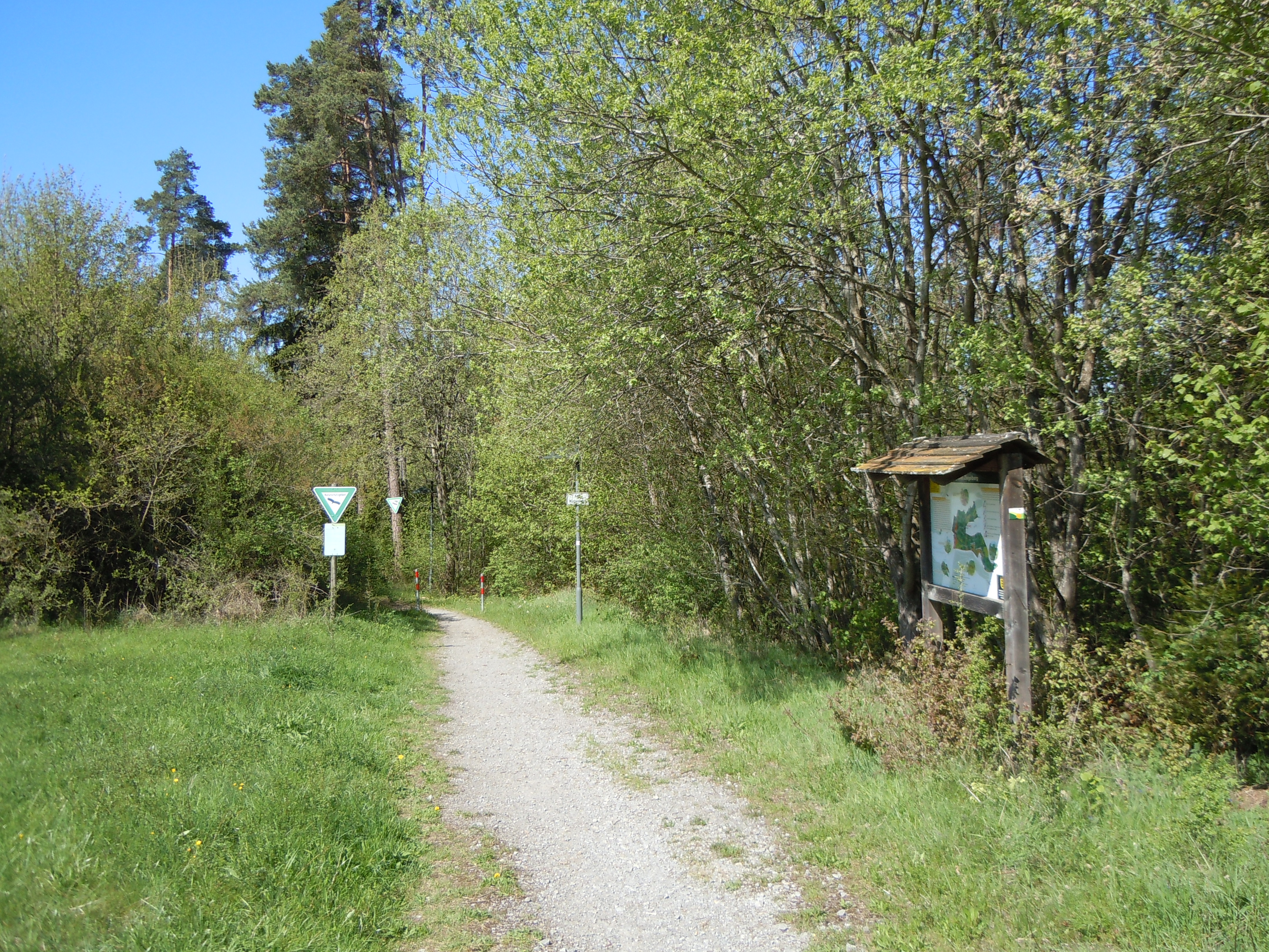 Weg ins Schutzgebiet mit Informationstafel.