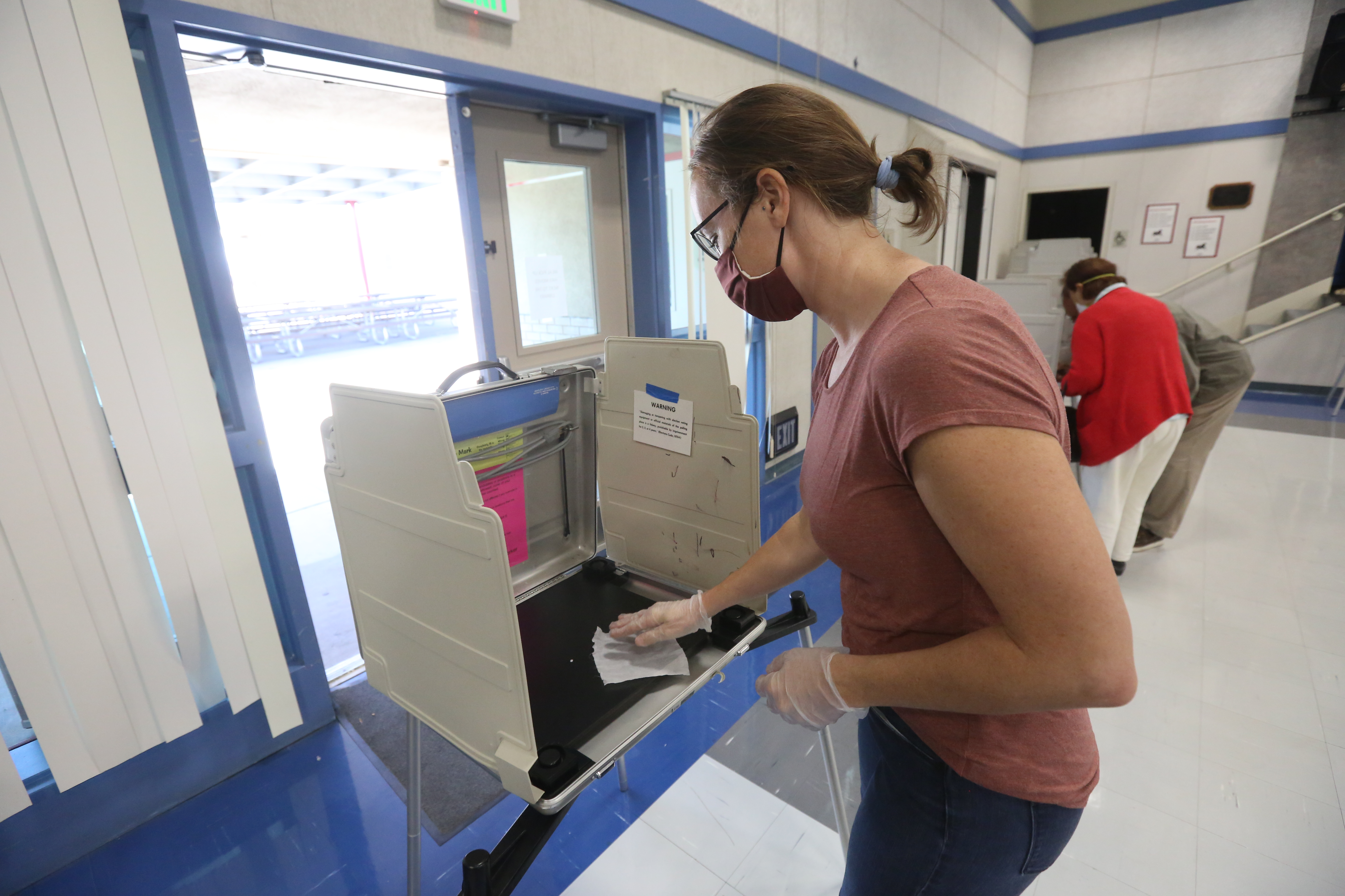 Owen Yancher, "A California poll worker sanitizes a voting booth following its use at a Voter Assistance Center in Davis, CA during the 2020 General Election," October 31, 2020, Wikimedia Commons, https://commons.wikimedia.org/wiki/File:Poll_worker_sanitizes_election_booth.jpg. 