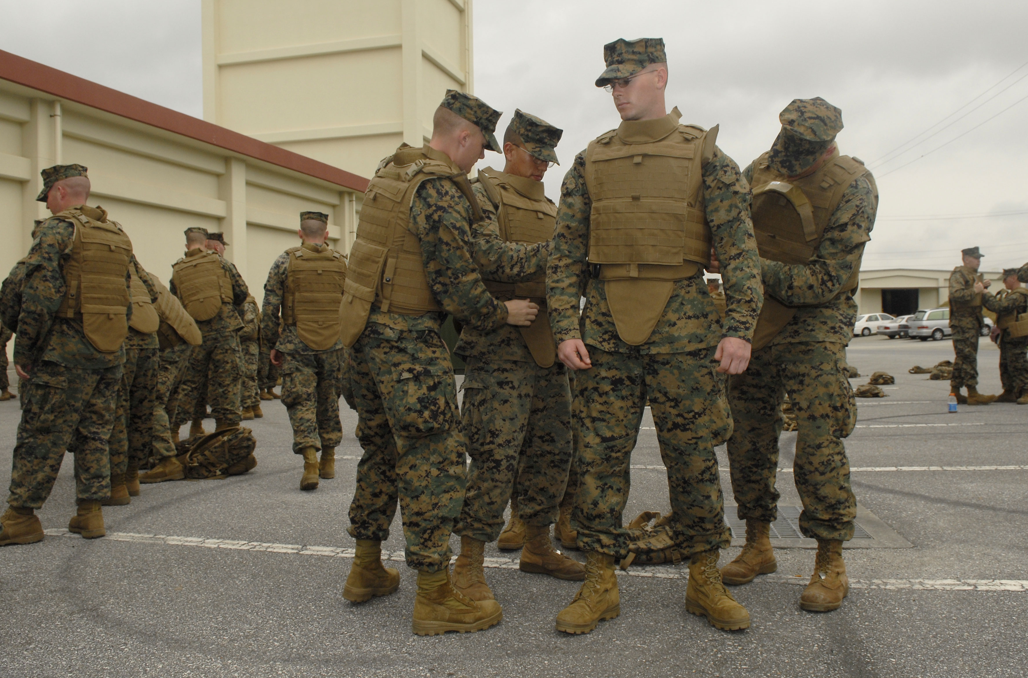 a group of Marines being trained to configure and wear the Modular Tactical Vest