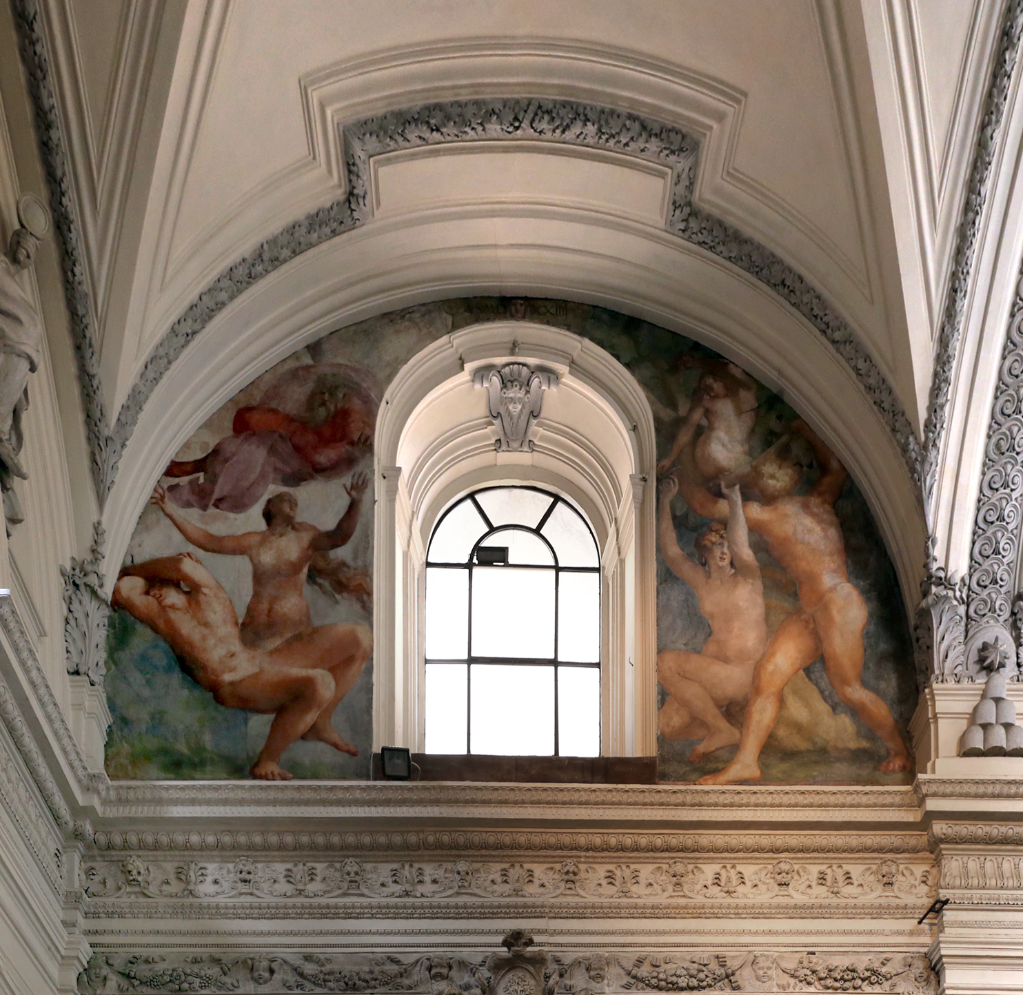 Rosso fiorentino mural on the upper-wall of a grand room. There is an arched-window in the center with various naked figures surrounding it. 