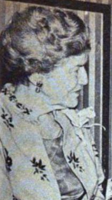 An older white woman wearing a floral jacket, photographed in profile