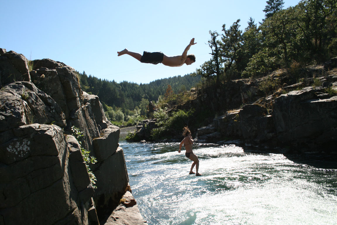 Man and woman jumping off a cliff in Glide, Oregon.