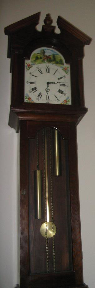 Most of a longcase clock's height is used to hold the long pendulum and weights. The two chains attached to the weights and the lack of winding holes in the dial show this to be a 30-hour clock.