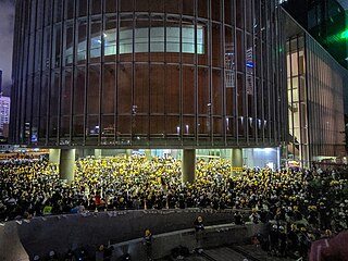 Hundreds of protesters near LegCo Building wearing protective helmets at night