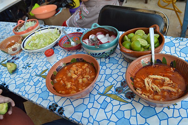 Red pozole with common accompaniments (including lime, shredded lettuce, and sliced radish) (Mexico City, 2015)