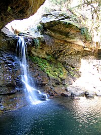 Small waterfall over a small sandstone cliff into water