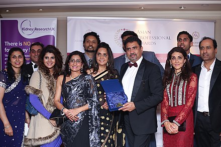 An Asian business leader showcasing his awards at the Grange Hotel in London