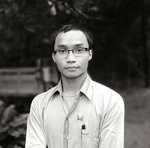 Photo of a man wearing glasses and smile.