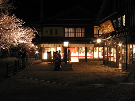 Illuminated cherry blossoms, light from the shop windows, and Japanese lantern at night in Ise, Mie, Japan