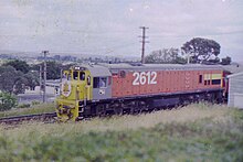 D 2612 (DX5137) at Avondale in Auckland in the late 1970s. Note the two small windows in the cab of the locomotive, replaced in 1988 with a single-window as a result of single-crewing. Dx2612 (8371714655).jpg