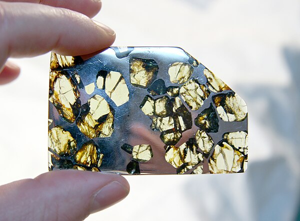 A slice of the Esquel pallasite, clearly showing the large olivine crystals suspended in the metal matrix.