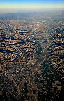 Late-afternoon aerial view of Fillmore (left foreground) and the Santa Clara River Valley. State route 126 runs along the valley, to Castaic Junction at the east end. Fillmore and Santa Clara River.jpg