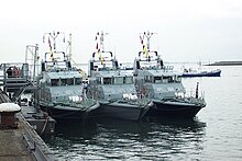 HMS Example and HMS Explorer seen either side of HMS Archer, demonstrating the distinctive black hull of the RNXS Example Class. HMS Example (P165) & HMS Archer (P264) & HMS Explorer (P165).jpg