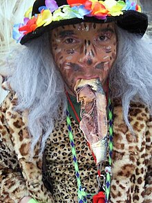 Photo d'un carnavalier costumé, avec un hareng fumé dans la bouche