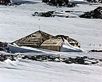 Kap Denison, Commonwealth-Bucht, George-V.-Land, Ostantarktika. Es handelt sich um eine der wichtigsten Stätten früher menschlicher Aktivität in der Antarktis, an der sich auch die Basis der Australasiatischen Antarktisexpedition 1911–1914 befand, die von Douglas Mawson organisiert und geleitet wurde und wo sich eine von nur sechs Hütten befindet, die noch aus der „Heroischen Phase“ der Eroberung der Antarktis 1895–1917 erhalten ist. Die Historische Stätte ist gleichzeitig als besonders verwaltetes Gebiet der Antarktis ASMA-3 ausgewiesen und schließt wie dieses das besondere antarktische Schutzgebiet ASPA-162 ein.[Anm 1]