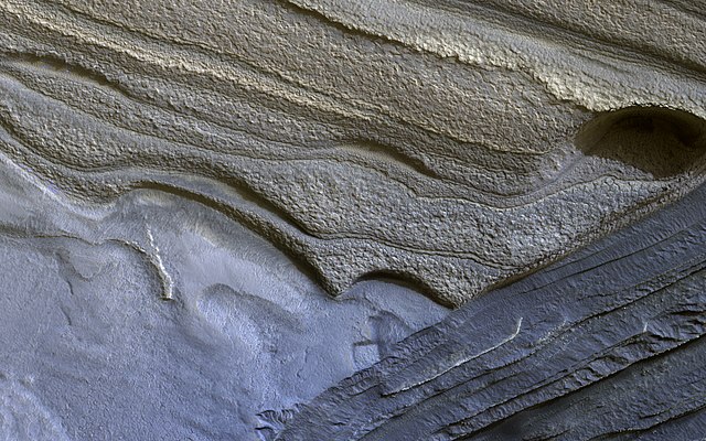 Structures ondulées claires représentant des couches de glace.