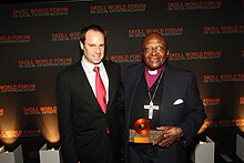 Image shows Jeffery Skoll and Desmond Tutu at the Skoll Awards for Social Entrepreneurship