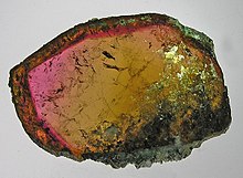 A stone cut open and polished, revealing a bright rainbow of colors