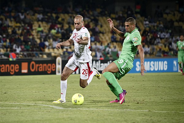 Slimani being tackled by Tunisian Aymen Abdennour at the 2013 Africa Cup of Nations