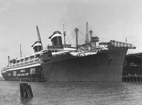 America being converted to USS West Point in Norfolk Ship Yards. The carrier USS Hornet can be seen behind her.