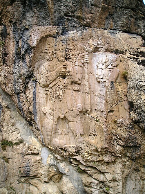 The Hittite King Warpalawa offering a bunch of grapes to the god Tarhunta. A bas-relief in rock at Ivriz in Turkey from the beginning of the 1st mille