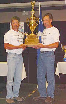 Champions of the 2002 Triple Crown Canoe Racing, their third Triple Crown Championship in a row, [left] Jeff Kolka, 43, of Grayling, Michigan, and Serge Corbin, 45, of St-Boniface de Shawinigan, Quebec 2002 Triple Crown of Canoe Racing Champions.jpg