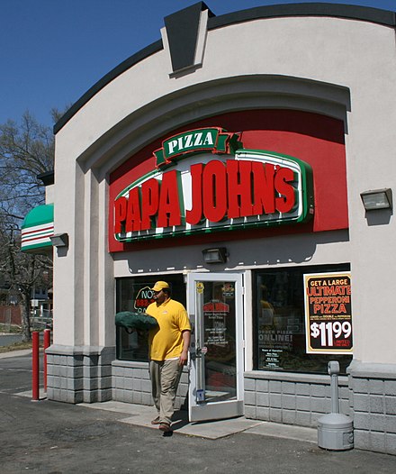 A Papa John's employee delivering a pizza