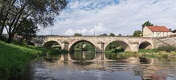 Ponte gótica de pedra (1515) sobre o rio Nysa Kłodzka em Bardo, Baixa Silésia, Polônia. Um rio no sudoeste da Polônia, nas voivodias da Baixa Silésia e Opole, um afluente da margem esquerda do rio Óder. Em seu curso superior, flui rapidamente, formando cachoeiras, e serpenteia fortemente na planície. Muitas vezes transborda, e é por isso que dois grandes reservatórios de retenção foram construídos próximo de Otmuchów (lago Otmuchowskie) e Nysa (lago Nyskie) no século XX, que também são usados ​​para fins energéticos e recreativos. Em parte de seu curso, é a fronteira tradicional entre a Alta e a Baixa Silésia. (definição 4 716 × 2 166)