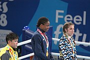 Deutsch: Boxen bei den Olympischen Jugendspielen 2018 Tag 12, 18. Oktober 2018 - Medaillenzeremonie im Leichtgewicht der Mädchen - Gold: Caroline Sara DuBois (Großbritannien), Silber: Porntip Buapa (Thailand), Bronze: Oriana Saputo (Argentinien); Medaillenübergabe durch Habu Gumel (IOC, Nigeria), Geschenkübergabe durch Raymond Silvas (USA, AIBA). English: Boxing at the 2018 Summer Youth Olympics on 18 October 2018 – Girl's Lightweight Medal Ceremony - Gold: Caroline Sara DuBois (Great Britain), Silver: Porntip Buapa (Thailand), Bronze: Oriana Saputo (Argentina); Medal handover by Habu Gumel (IOC, Nigeria), Gift presented by Raymond Silvas (USA, AIBA). Español: Boxeo en los Juegos Olímpicos Juveniles de Verano de 2018 en 18 de octubre de 2018 - Ceremonia de la Medalla de peso ligero para niñas - Oro: Caroline Sara DuBois (Gran Bretaña), Plata: Porntip Buapa (Thailand), Bronce: Oriana Saputo (Argentina); Entrega de medallas por Habu Gumel (COI, Nigeria), Regalo presentado por Raymond Silvas (EE. UU., AIBA).
