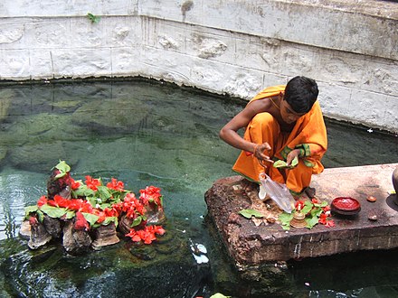 A young Hindu priest performing religious rituals at Taptapani hot spring