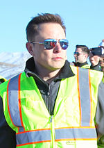 Elon Musk on a March 2015 tour of construction Elon Musk oveseeing the construction of Gigafactory (16549440890).jpg