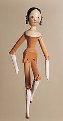 A Dutch doll, a wooden peg construction giving a stiff doll with hinged joints, illustrates the type of toy that inspired the name Tom Bombadil. The one owned by the Tolkien family had a hat with a feather. Gliederpuppe.jpg