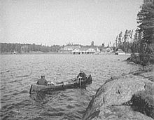 Guide boat, Lower Saint Regis Lake, Paul Smith's in background, 1903 Guide boat - Paul Smiths Hotel.jpg