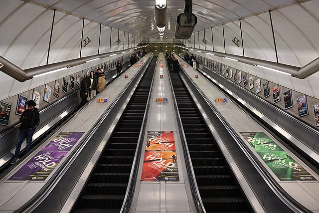 View up the inclined main escalator shaft with four escalators in a line carrying passengers up and down.