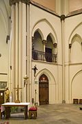 Photo de l'intérieur de la Bonifatiuskerk montrant la porte à gauche de l'autel menant vers l'entresol et son balcon visibles au-dessus de la porte.