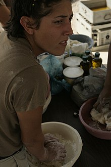 Spc. Stacy R. Mull, an enrolled Muscogee person from Okemah, makes frybread at a powwow at Camp Taqaddum, Iraq, 2004. Making Frybread.jpg