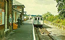 London Underground train calls at the station in 1980 Ongar railway station in 1980.jpg