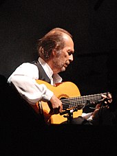 Fotó egy ember gitározni