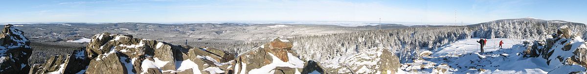 Winter at the Wolfswarte between Altenau and Torfhaus im Harz: Altenau can be seen on the left between the rocks, the Brocken on the far right.
