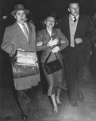 רעייתו של פטרוב, אשר לא ידעה על עריקת בעלה, מובלת למטוס על ידי שני סוכני ביון סובייטיים חמושים.