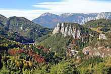 Das „Kernstück“ der Semmeringbahn, seit 1998 UNESCO-Weltkulturerbe, mit der Rax im Hintergrund. Ganz rechts der Krauseltunnel, kürzester Tunnel Österreichs.
