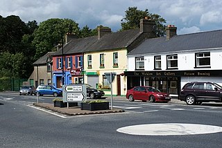 Picture of Village Centre with shops, and road signs.