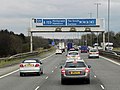 The A723 road is a non-primary road – that is, a road that carries the non-primary route network – where all the signs along the road are in white. But at this approach to the road on a motorway, the number is rendered in plain text against the same blue background as all the signs along the motorway.