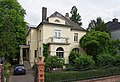 Trier, Katharinenufer 1, neuklassizistische Villa, 1920, Architekten Peter Marx und Peter Gracher, unter Verwendung der Außenmauern des Vorgängers; verschachtelter Walmdachbau mit risalitartigen Schmalseiten mit niedrigeren Walmdächern; mit Ausstattung