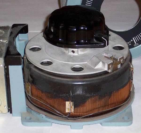 A variable autotransformer, with a sliding-brush secondary connection and a toroidal core. Cover has been removed to show copper windings and brush.