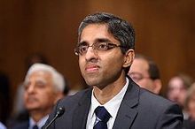 Vivek Murthy seated facing a microphone with an audience behind him